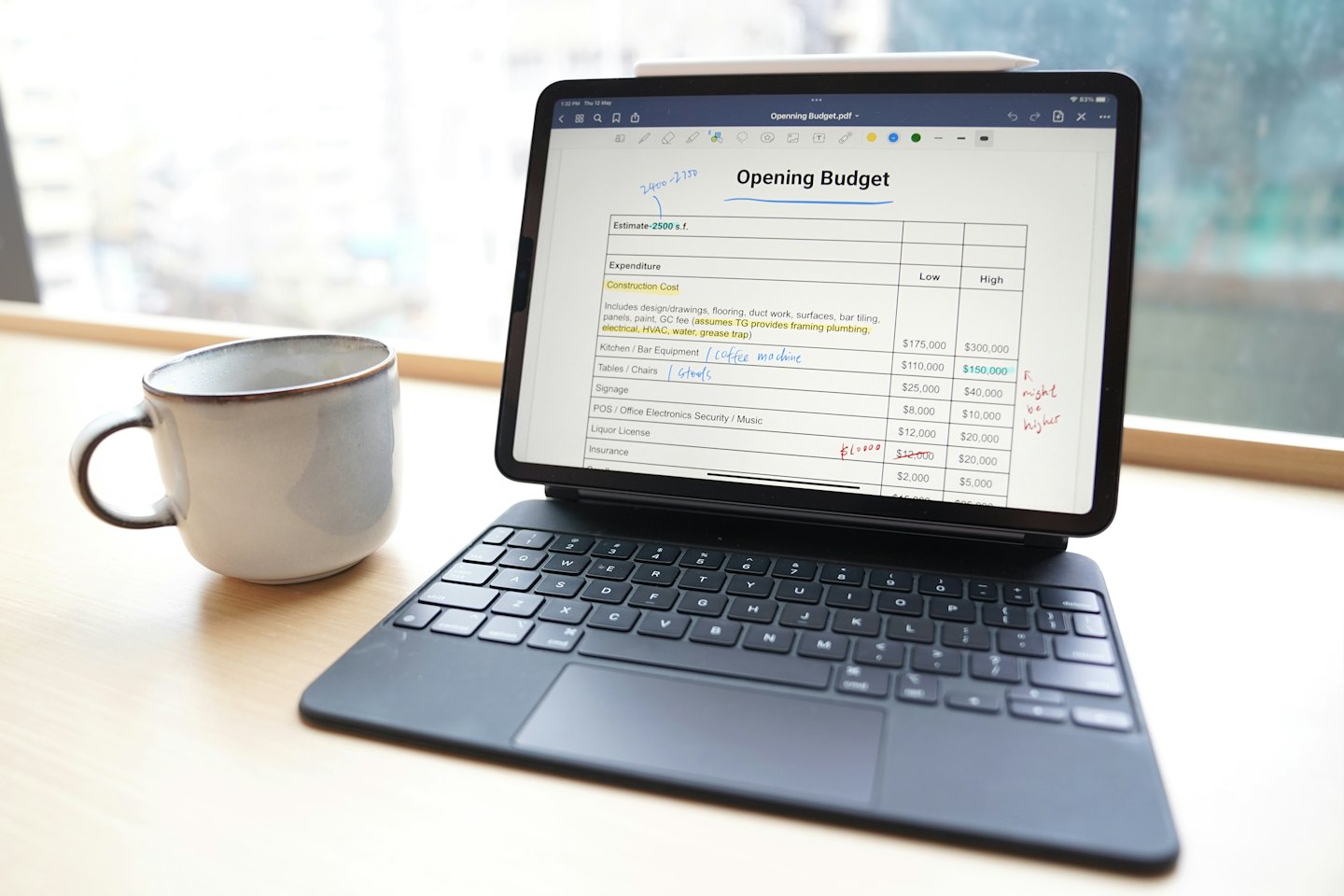 Na biurku leży tablet z dokumentem budżetowym i odręcznymi notatkami.